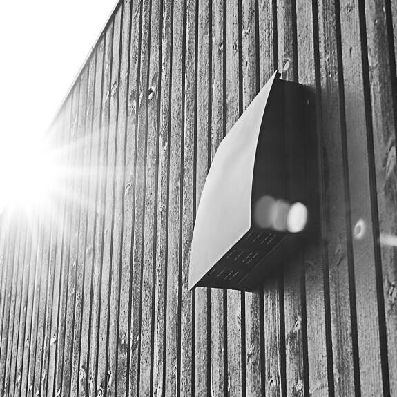 DUKA One DO 30 storm shield in black on spacer placed on a black wooden wall